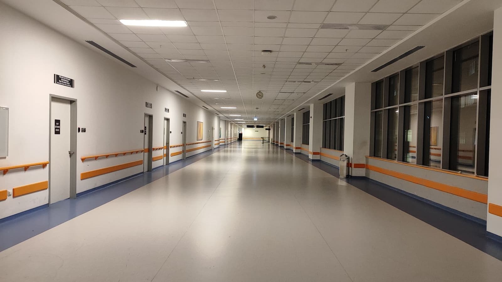 Pasillo amplio y bien iluminado de un hospital moderno, sin personas.