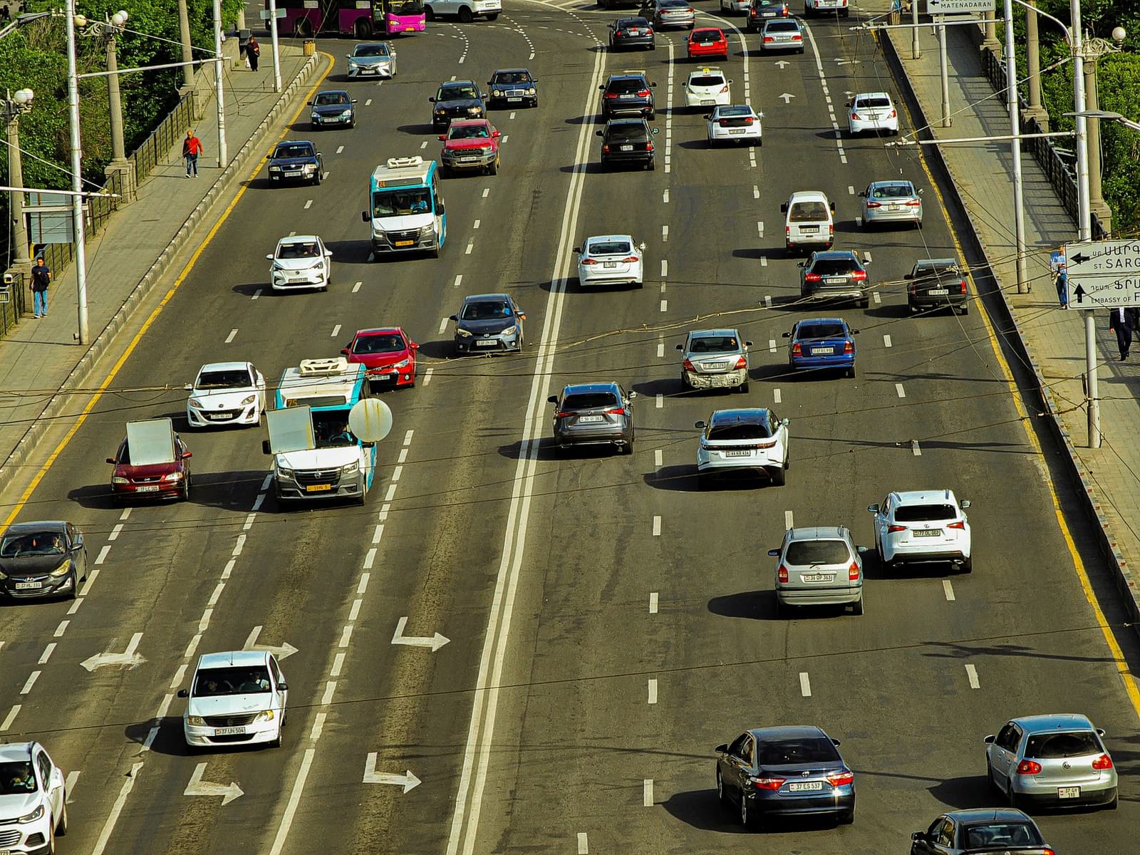 Vista elevada de una autopista urbana con varios carros circulando.