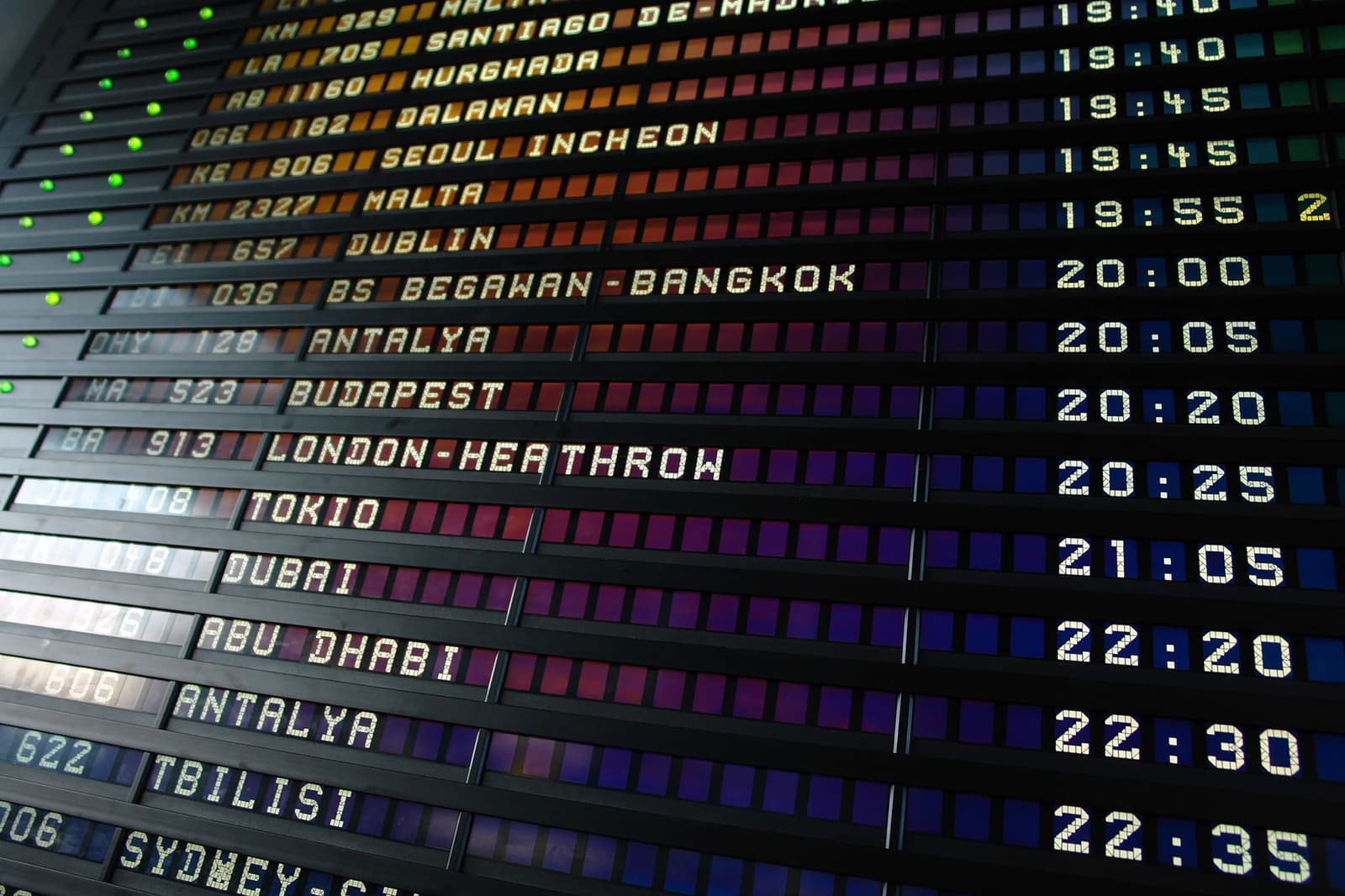 Panel de salidas de aeropuerto de tipo mecánico mostrando vuelos internacionales.